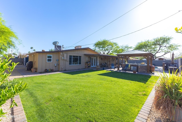 back of house featuring a gazebo, a fenced backyard, a lawn, and a patio