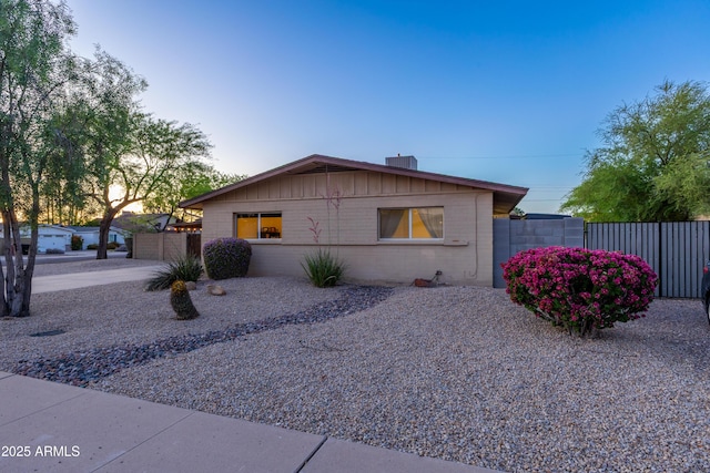 ranch-style home featuring fence and concrete block siding