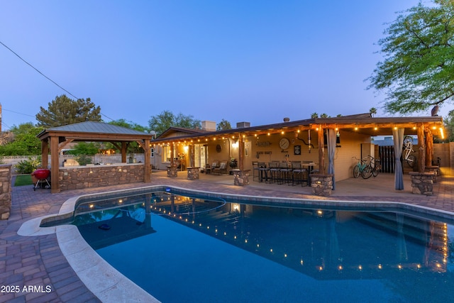 pool with outdoor dry bar, a patio, and a gazebo