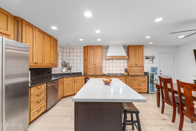kitchen with backsplash, a sink, appliances with stainless steel finishes, and custom exhaust hood