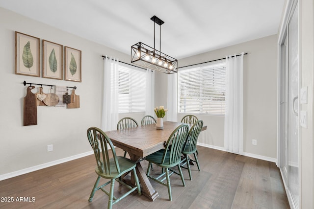 dining area with wood-type flooring and a notable chandelier