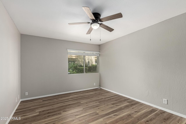 spare room with ceiling fan, baseboards, and wood finished floors