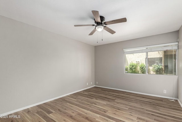 empty room featuring baseboards, a ceiling fan, and wood finished floors