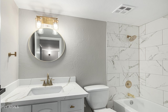full bathroom featuring toilet, visible vents, vanity, washtub / shower combination, and a textured wall