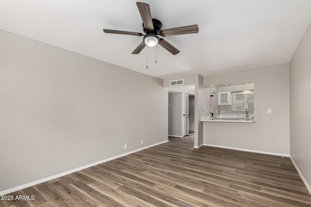 unfurnished living room featuring baseboards, visible vents, wood finished floors, and a ceiling fan
