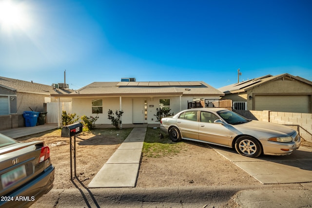 ranch-style home featuring solar panels