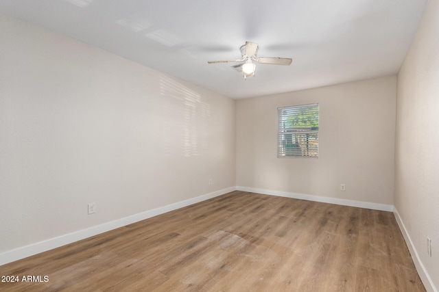 empty room with ceiling fan and light hardwood / wood-style flooring