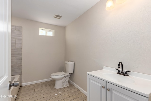 bathroom with hardwood / wood-style floors, vanity, and toilet