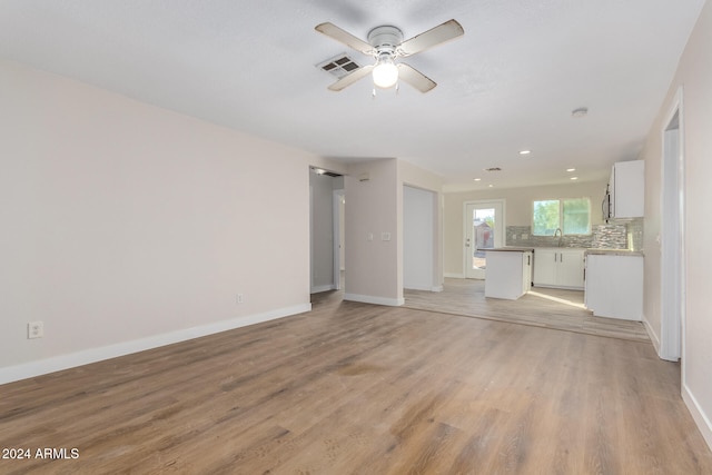 unfurnished living room featuring ceiling fan and light hardwood / wood-style floors