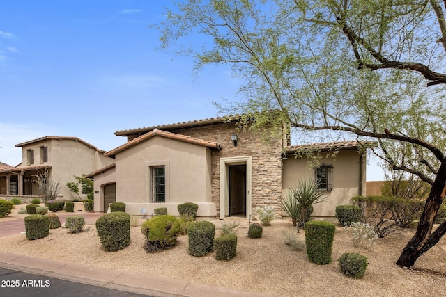 20055 N 96th Way, Scottsdale, AZ 85255 - mediterranean / spanish-style home featuring an attached garage, stucco siding, stone siding, and a tile roof