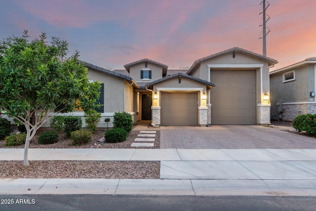 view of front of home featuring a garage, stucco siding, and driveway