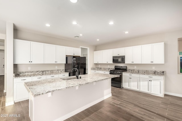 kitchen with a sink, baseboards, black appliances, and recessed lighting