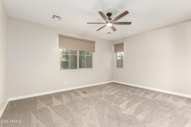 empty room featuring ceiling fan, carpet floors, baseboards, and visible vents