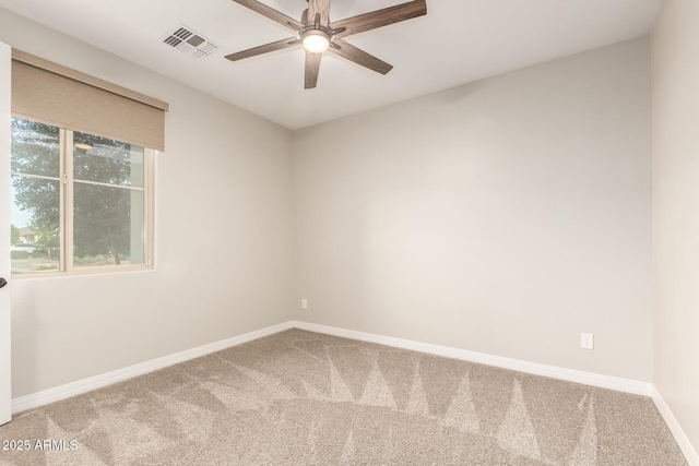carpeted empty room with visible vents, baseboards, and a ceiling fan