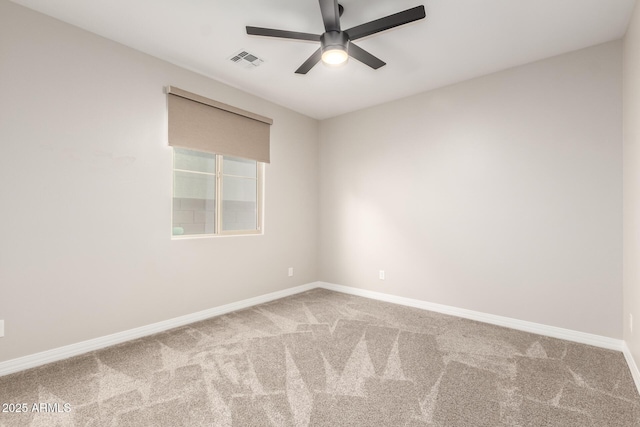 carpeted empty room with visible vents, baseboards, and ceiling fan