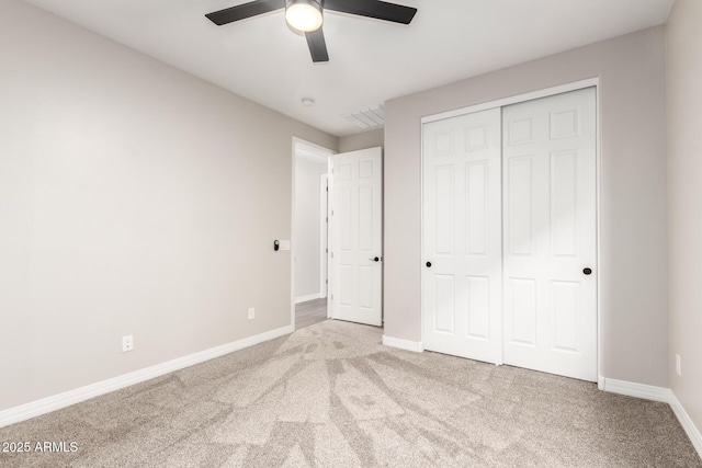 unfurnished bedroom featuring carpet, baseboards, a closet, and a ceiling fan