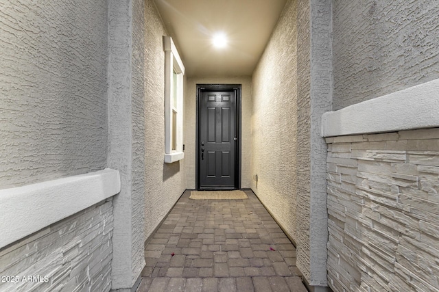doorway to property featuring stucco siding