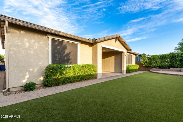 exterior space featuring a front lawn and stucco siding