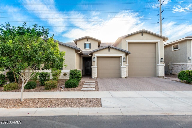 view of front of house with a garage, stucco siding, and driveway