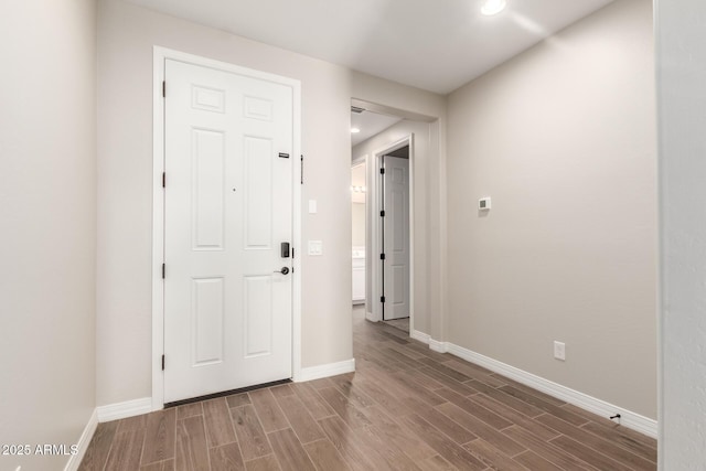 interior space featuring recessed lighting, baseboards, and wood finished floors