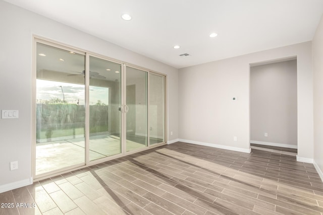unfurnished room with wood finished floors, baseboards, and recessed lighting