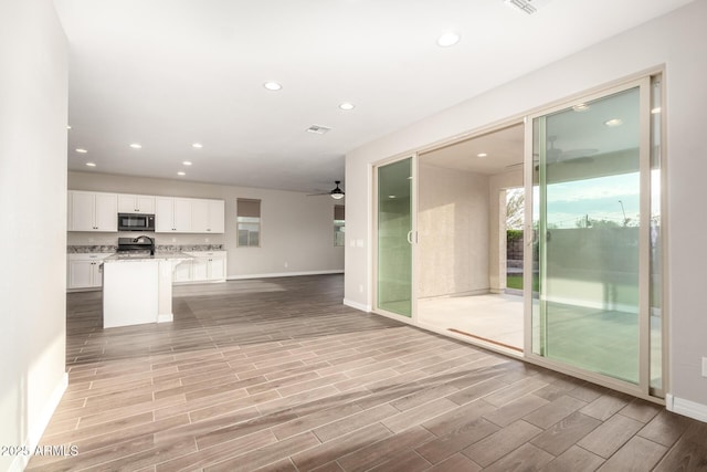 unfurnished living room featuring baseboards, a ceiling fan, and recessed lighting