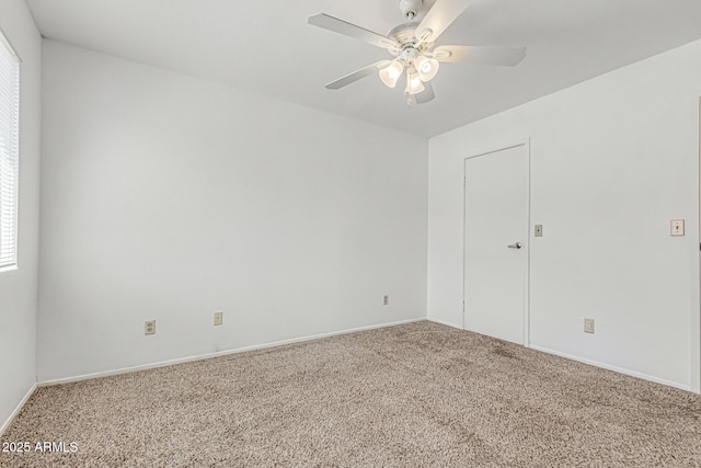 carpeted empty room with baseboards, a ceiling fan, and a wealth of natural light