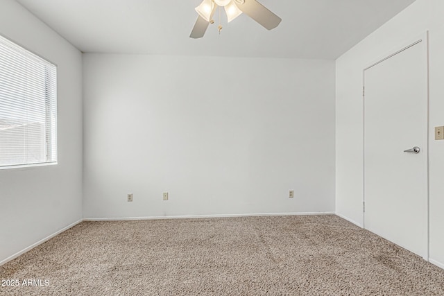 unfurnished room featuring baseboards, ceiling fan, a wealth of natural light, and carpet