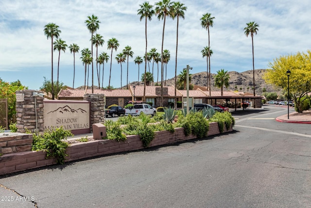 community sign with covered and uncovered parking and a mountain view