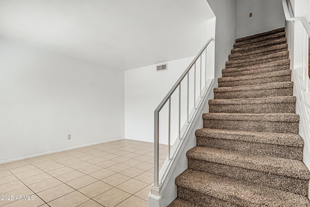 stairs featuring visible vents, baseboards, and tile patterned flooring
