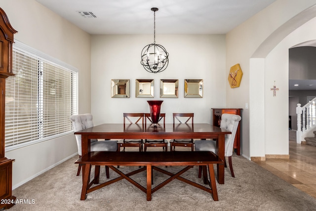 carpeted dining space featuring a notable chandelier