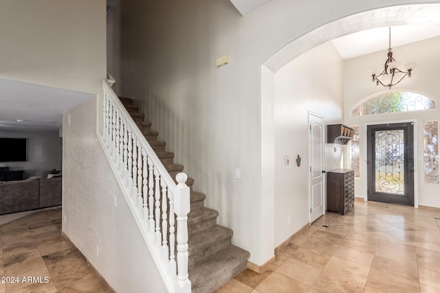 tiled foyer featuring a chandelier and a towering ceiling