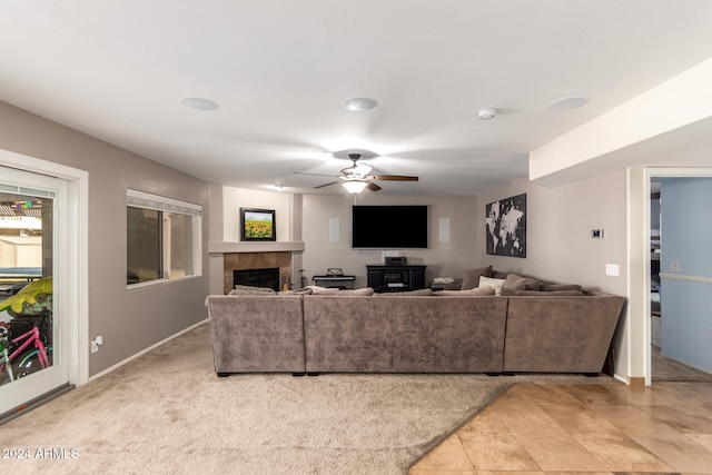 carpeted living room with ceiling fan and a fireplace