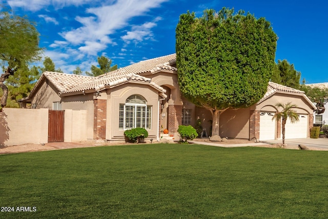 mediterranean / spanish-style home featuring a garage and a front yard