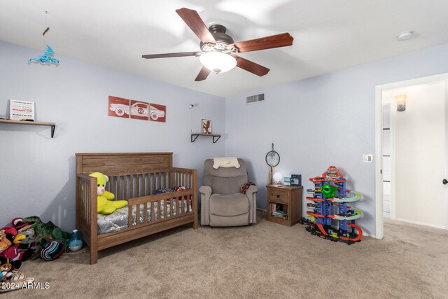 carpeted bedroom with a nursery area and ceiling fan