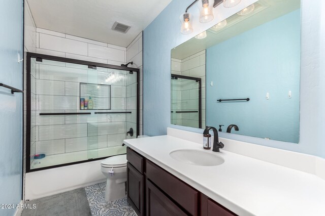 full bathroom featuring bath / shower combo with glass door, vanity, and toilet