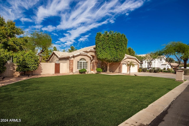 mediterranean / spanish-style home featuring a garage and a front yard