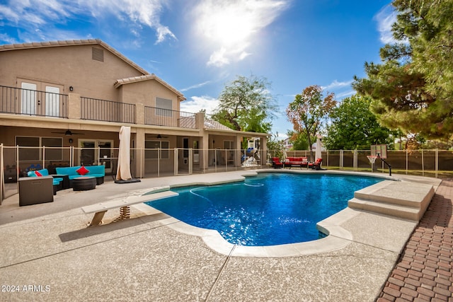 view of swimming pool with a diving board, a patio, and an outdoor living space