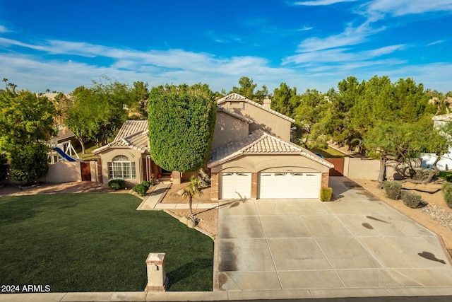 mediterranean / spanish house with a garage and a front yard