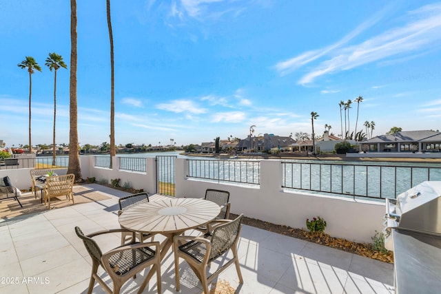 view of patio / terrace featuring grilling area and a water view