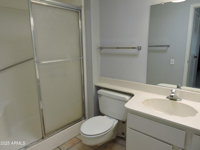 bathroom featuring tile patterned flooring, vanity, a shower with shower door, and toilet