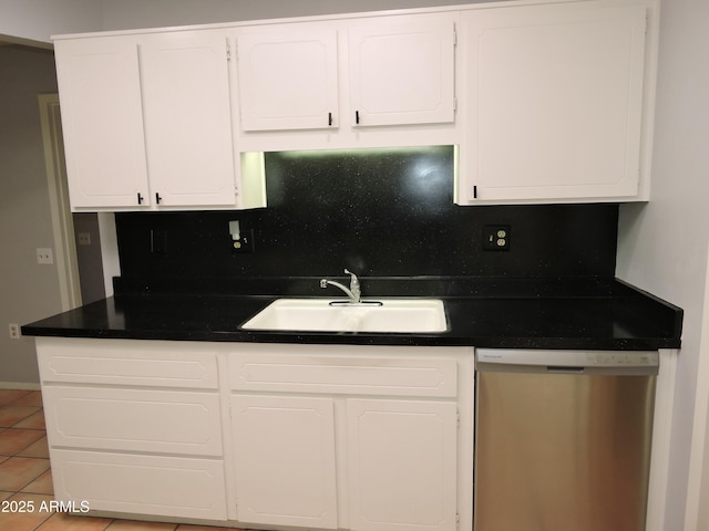 kitchen with tasteful backsplash, sink, white cabinets, stainless steel dishwasher, and light tile patterned floors