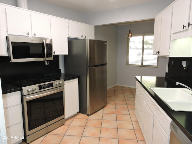 kitchen with decorative light fixtures, white cabinetry, sink, light tile patterned floors, and stainless steel appliances