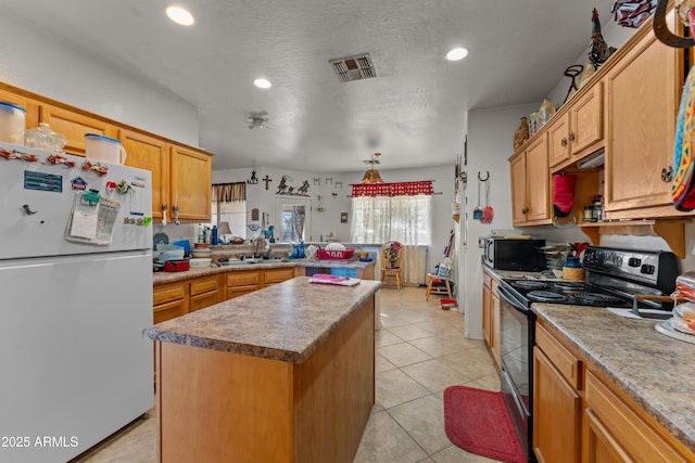 kitchen with sink, a center island, light tile patterned floors, black appliances, and a textured ceiling