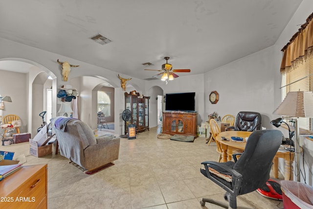 tiled living room with a wealth of natural light and ceiling fan