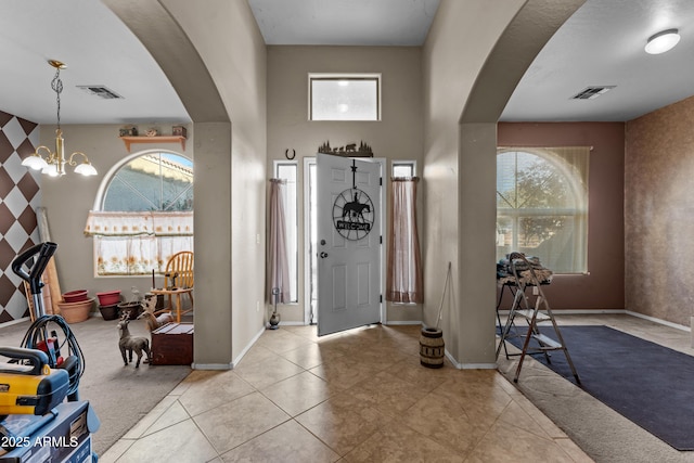 entrance foyer with light tile patterned floors and a notable chandelier