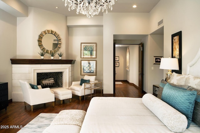 bedroom featuring visible vents, a notable chandelier, hardwood / wood-style flooring, recessed lighting, and a fireplace