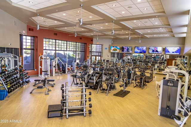 workout area with visible vents, coffered ceiling, and wood finished floors