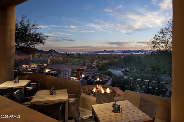 exterior space with an outdoor fire pit, outdoor dining area, and a balcony