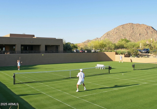 view of sport court with a mountain view, community basketball court, and fence